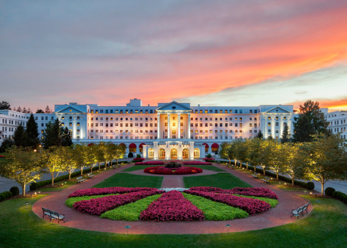 The Greenbrier resort during sunset with colorful gardens and lawns lit up in front