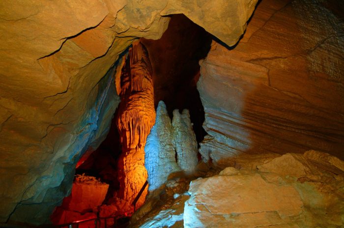 Underground cave formations lit up orange and blue